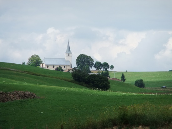 een alpeweide met kerk in het Jura